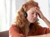 curly-woman-touching-her-forehead-while-feeling-di-CX8K37J.jpg